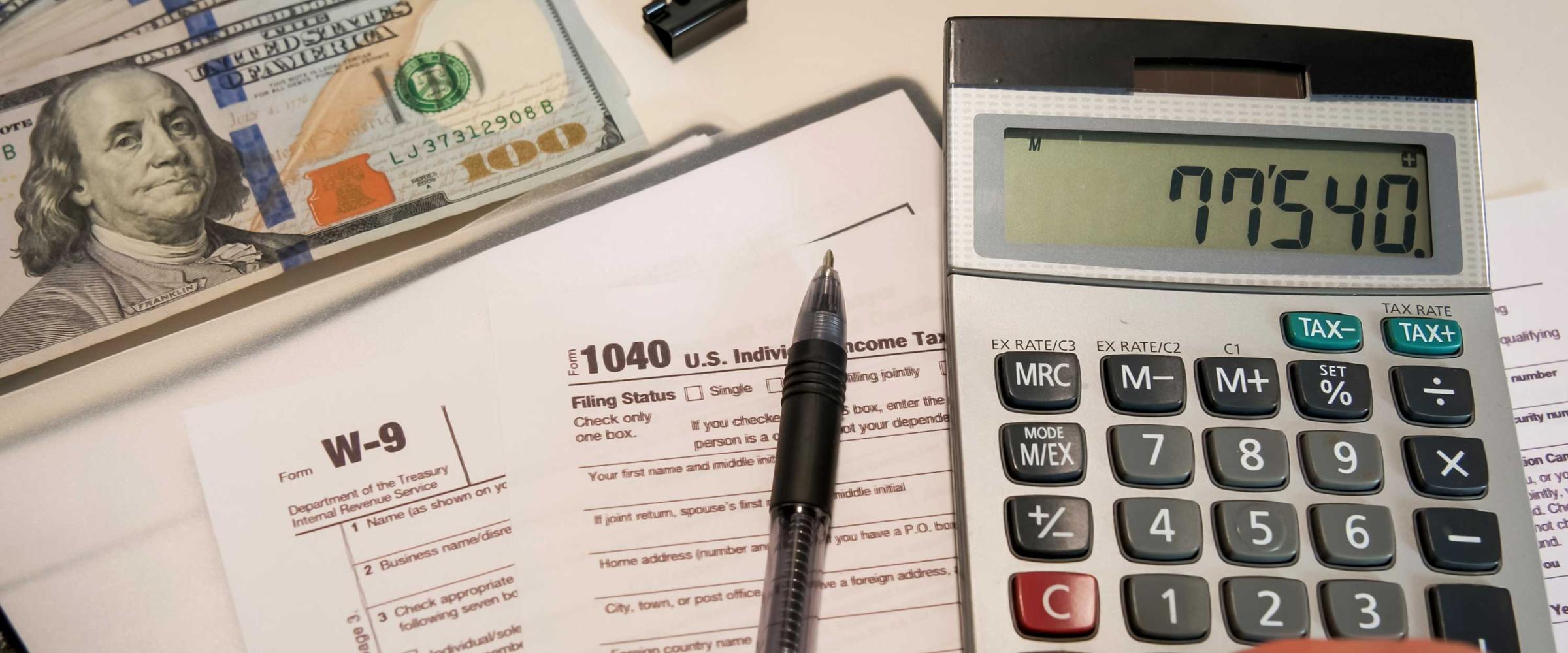 Photo of W9 forms and a calculator
